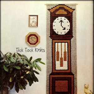 May include: A crocheted wall hanging depicting a grandfather clock with a white clock face and brown and tan details. The text "Tick Tock Knits" is visible. The image also shows decorative items, including framed art, plants, and ceramic cat figurines.