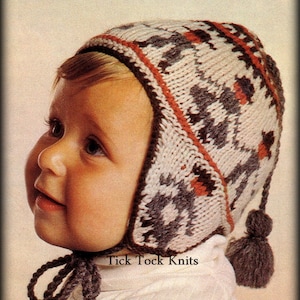 May include: A baby wearing a white, gray, and red knitted hat with ear flaps and a pom-pom. The hat has a geometric pattern and the text "Tick Tock Knits" is visible on the hat.