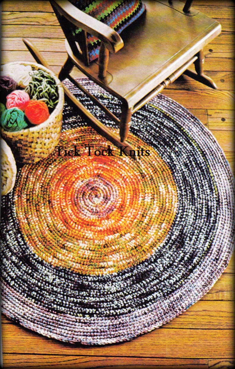 May include: A colorful crocheted rug with a circular design. The rug has a dark purple outer edge, a yellow and orange center, and a brown rocking chair in the background.