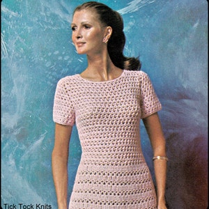 Peut inclure: Une robe en crochet rose à manches courtes et un col rond. La robe présente un délicat motif ajouré. L'image comprend le texte "Tick Tock Knits".