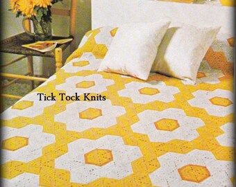 May include: A white and yellow crocheted bedspread with a geometric pattern. The bedspread is on a bed with two white pillows. The text "Tick Tock Knits" is visible on the bedspread.