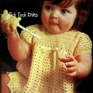 Puede incluir: Una niña pequeña con un vestido de crochet amarillo con un lazo amarillo en la cintura. El vestido tiene un dobladillo festoneado. La niña sostiene un juguete amarillo en su mano. El texto "Tick Tock Knits" es visible en la imagen.
