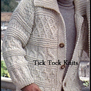 Puede incluir: Un cárdigan de punto de color crema con un patrón de punto de cable y un cuello grande. El cárdigan tiene cierre de botones y dos bolsillos. El texto "Tick Tock Knits" es visible en la parte delantera del cárdigan.