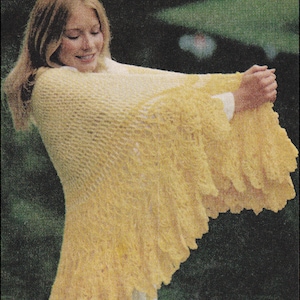 May include: A yellow crocheted shawl with a lacy pattern. The shawl is draped over a person's shoulders and arms.