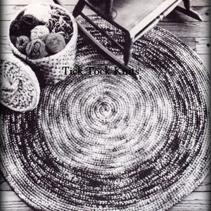 May include: A black and white crocheted round rug with a concentric circle pattern. The rug is on a wooden floor and there is a rocking chair and a basket of yarn in the background. The text "Tick Tock Knits" is visible in the image.