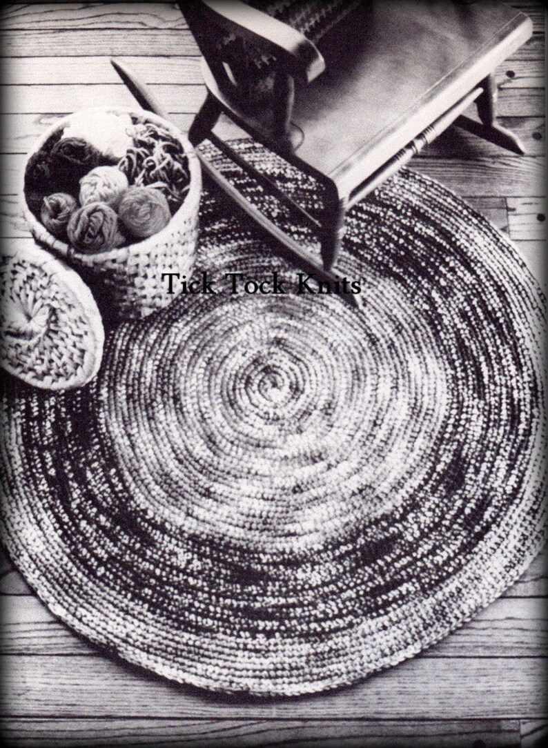 May include: A black and white crocheted round rug with a concentric circle pattern. The rug is on a wooden floor and there is a rocking chair and a basket of yarn in the background. The text "Tick Tock Knits" is visible in the image.