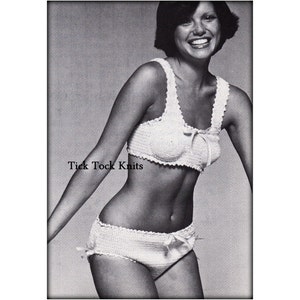 Op de afbeelding: Een wit gehaakt bikini-topje en -broekje met een strikdetail. De bikini wordt getoond op een model met kort donker haar. De tekst "Tick Tock Knits" is op de afbeelding gedrukt.