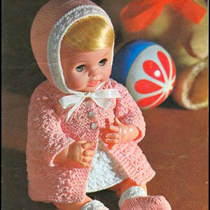May include: A pink knitted coat, hat, and booties for a 12 or 14 inch doll. The pattern is called "Carefree" and is from Coats Tick Tock Knits.
