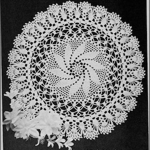 May include: A white crocheted doily with a spiral design. The doily is on a black background. The text "Tick Tock Knits" is at the bottom of the image.
