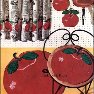 May include: A set of three red knitted apple pot holders with green leaves. The pot holders are hanging on a pegboard with a copper pot and a black handle. The text "Tick Tock Knits" is printed on the image.