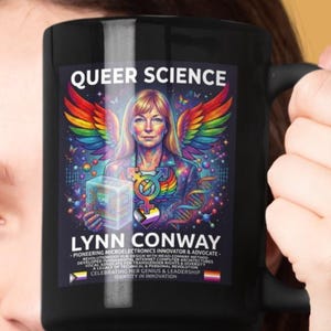 May include: Black ceramic mug featuring the text "QUEER SCIENCE" and an illustration of Lynn Conway with rainbow wings and a gender symbol. The mug also includes text about Conway's achievements.