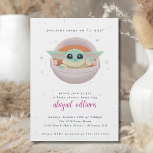 May include: Baby shower invitation featuring a cartoon character in a pod. The invitation text reads "precious cargo on its way!" and invites guests to celebrate Abigail Williams. The event is on October 12th at 3:00 PM.
