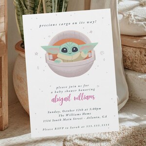 May include: Baby shower invitation featuring a cartoon character in a pod, with the text "precious cargo on its way!". The invitation includes details for a baby shower honoring Abigail Williams.