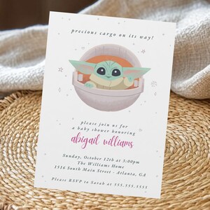 May include: A baby shower invitation featuring a cartoon character in a pod. The invitation includes the text "precious cargo on its way!" and details for a baby shower honoring Abigail Williams, including the date, time, and location.