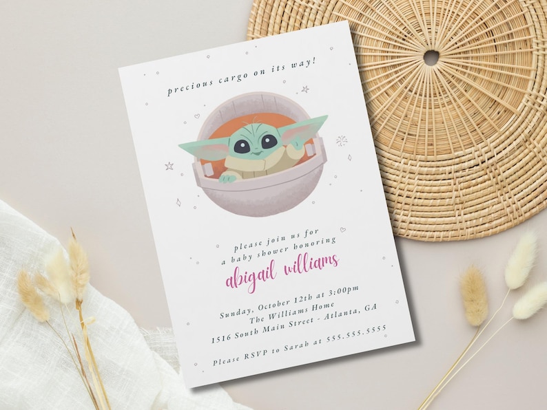 May include: A baby shower invitation featuring a cartoon image of a green alien character in a pod. The text reads "precious cargo on its way!" and invites guests to a shower honoring Abigail Williams. The date, time, and location are also included.