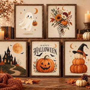 Op de afbeelding: Een set van vijf ingelijste wandkunstprints met Halloween-thema's, waaronder een geest met een pompoen, een skeletthand met bloemen, een spookhuis, een pompoen met de tekst Happy Halloween en gestapelde pompoenen.
