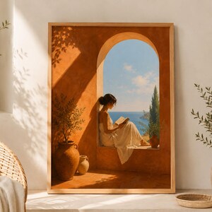 Può includere: Una stampa d'arte da parete incorniciata che raffigura una persona con un abito bianco seduta in una finestra ad arco mentre legge un libro. La scena presenta pareti color terracotta, una vista sul mare blu e sul cielo, e due vasi di terracotta.