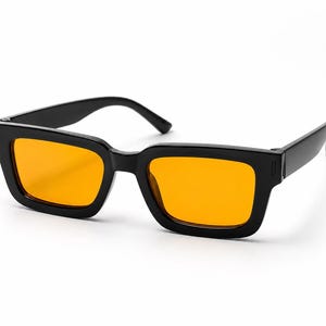 May include: Rectangular sunglasses featuring a glossy black plastic frame and vibrant orange tinted lenses. The design includes thick temples and a sturdy bridge, providing a bold look with clear, bright lenses that contrast against the dark frame.