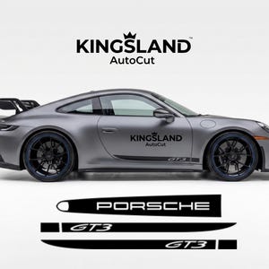May include: A silver Porsche GT3 sports car with black wheels and a rear spoiler. The car has black and white decals that say "Kingsland AutoCut" and "GT3". Below the car are black decals with the word "Porsche" and "GT3".