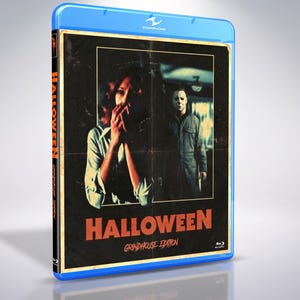 Może przedstawiać: Niebieskie etui na płytę Blu-ray z okładką Halloween Grindhouse Edition. Z przodu znajduje się postarzany obraz osoby z dłońmi przy twarzy oraz zamaskowanej postaci w tle. Tytuł Halloween jest wydrukowany w kolorze pomarańczowym.