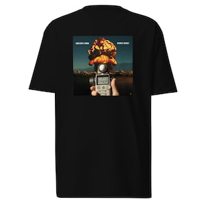 May include: Black t-shirt with a graphic on the back showing a vintage film camera aimed at a mushroom cloud explosion. The camera displays the word "0 FUCKS". The text "DIRECTOR'S VISION" and "STAN'S BUDGET" are above the image.