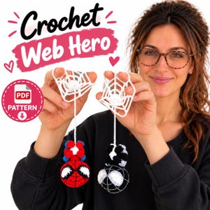 May include: Two crocheted ornaments featuring red and blue superhero-themed characters hanging from white yarn spiderwebs. The text Crochet Web Hero and PDF Pattern are visible. The ornaments are round with white eye patches.