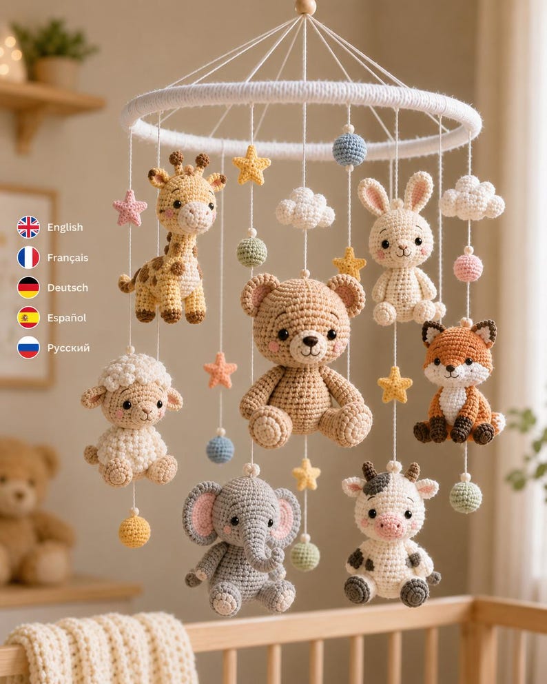 Pu&ograve; includere: Una giostrina per culla all'uncinetto con un orsetto beige centrale circondato da una giraffa, una pecora, un elefante, una mucca, un coniglio e una volpe. Gli animali sono appesi a un telaio circolare bianco con stelle, nuvole e sfere.