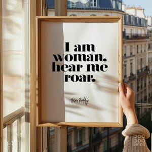 May include: A framed print with a quote that reads "I am woman, hear me roar." The quote is attributed to Helen Reddy.
