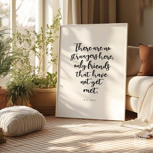 May include: A white framed print with a black quote that reads "There are no strangers here, only friends that have not yet met." The quote is attributed to W.B. Yeats.
