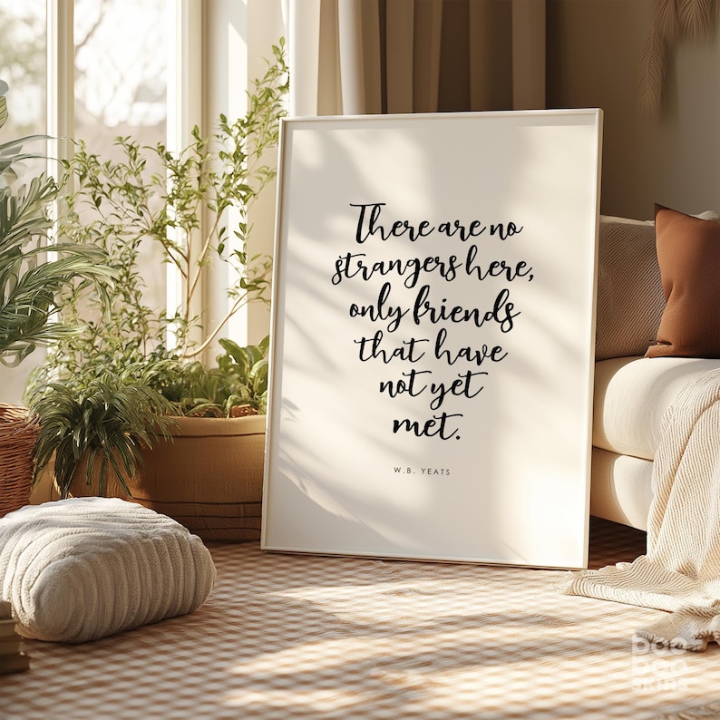 May include: A white framed print with a black quote that reads "There are no strangers here, only friends that have not yet met." The quote is attributed to W.B. Yeats.