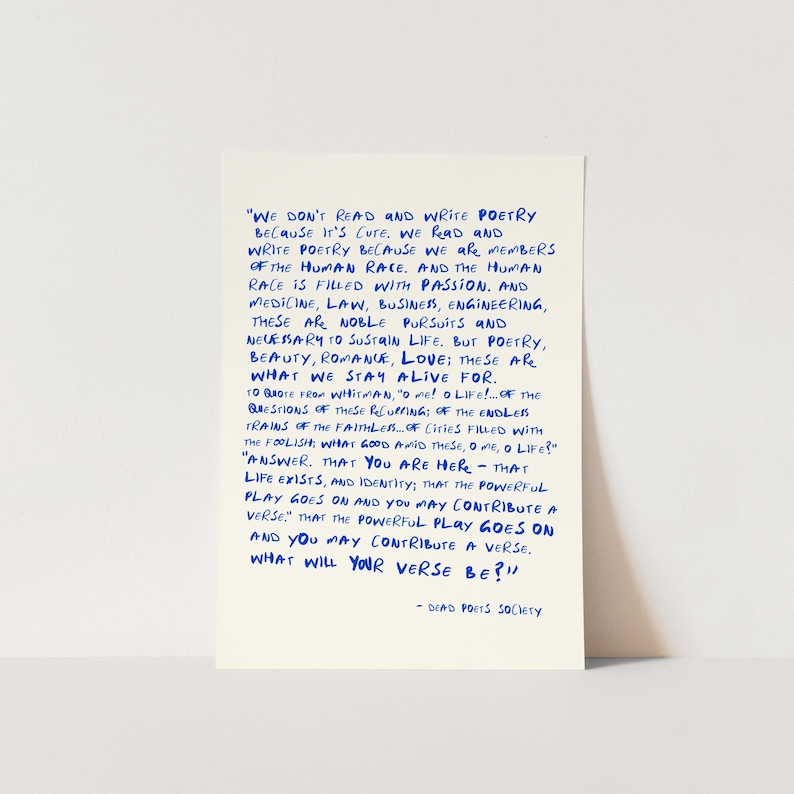 May include: A rectangular off-white print featuring a quote from Dead Poets Society written in blue ink. The text reads: We don't read and write poetry because it's cute. We read and write poetry because we are members of the human race.