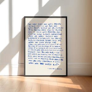 May include: A framed wall art print featuring a cream-colored background with handwritten-style blue text. The quote reads: We don't read and write poetry because it's cute. We read and write poetry because we are members of the human race.
