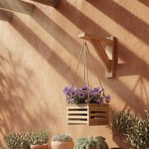 May include: A wooden hanging planter filled with purple flowers. The planter is suspended by rope from a wooden bracket mounted on a textured, peach-colored wall. The scene is bathed in sunlight, with shadows cast across the wall.