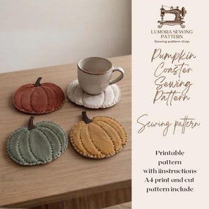 May include: A sewing pattern for pumpkin-shaped coasters by Lumora Sewing Pattern. The image displays three fabric pumpkin coasters in rust, sage green, and mustard yellow, plus one white coaster under a ceramic mug. Text includes Pumpkin Coaster Sewing Pattern.