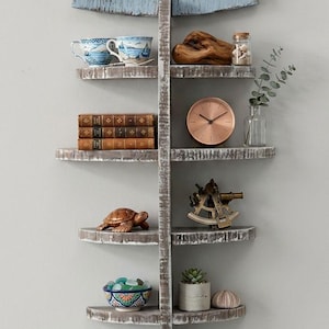 May include: A rustic, fish-shaped wall shelf painted in distressed blue and white. The shelf displays nautical-themed decor, including a teacup, books, a clock, and a small turtle figurine. The shelf is approximately 40 inches tall.