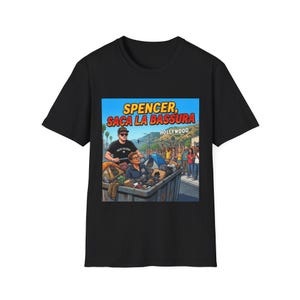 May include: Black t-shirt featuring a colorful graphic with the text "SPENCER, SACA LA BASSURA HOLLYWOOD". The graphic depicts two people in a trash bin being pushed by a person wearing a black shirt and sunglasses.