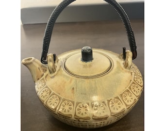Tetera de cerámica vintage fabricada en Japón con asa envuelta en relieve y diseño de cesta tejida.