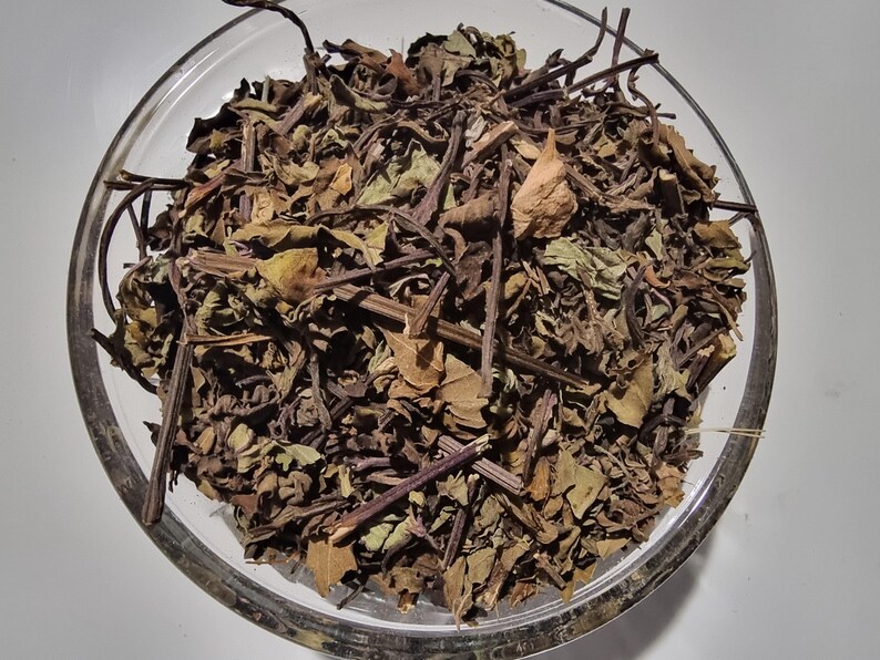 A glass bowl filled with dried herbs and leaves, creating a visually appealing and natural arrangement.