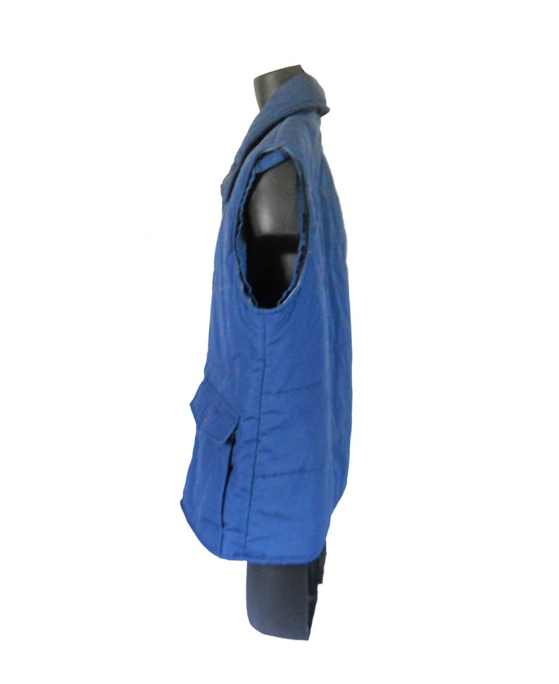 May include: A blue quilted vest with a zipper closure and a large pocket on the front.