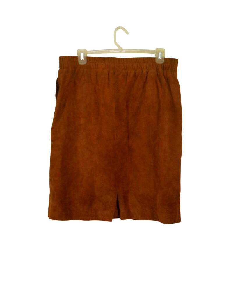 May include: A brown suede skirt with a straight silhouette and a small slit at the bottom.