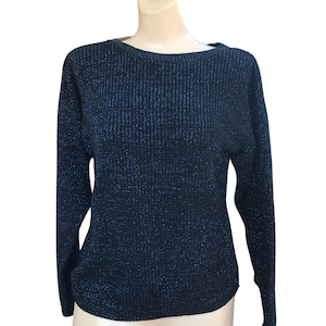 Puede incluir: Un suéter negro con brillo azul en todo. El suéter tiene mangas largas y un escote redondo.