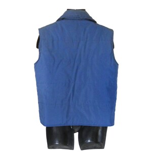 May include: A blue quilted vest with a zipper closure and a collar. The vest is sleeveless and has a smooth, quilted texture.