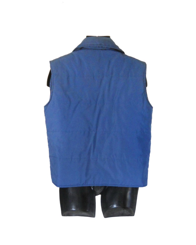 May include: A blue quilted vest with a zipper closure and a collar. The vest is sleeveless and has a smooth, quilted texture.