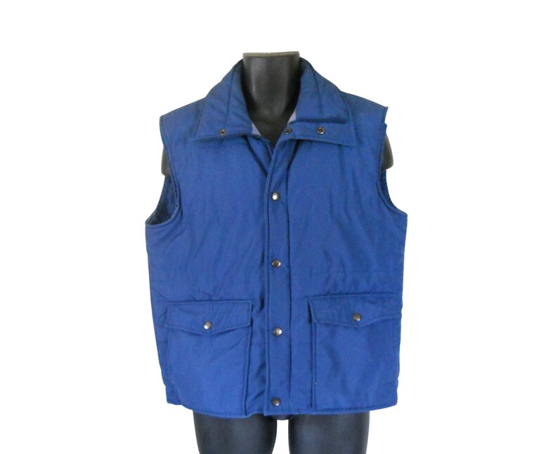 May include: A blue quilted vest with a snap closure and two front pockets.