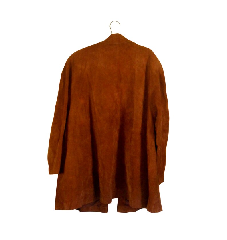 May include: A brown suede jacket with a long, flowing silhouette. The jacket has a simple design with a V-neck and long sleeves.