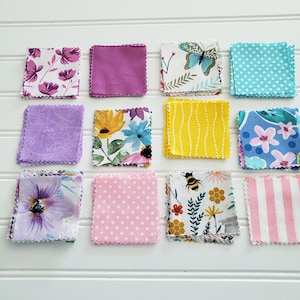 May include: A collection of twelve square fabric swatches with pinked edges, featuring various patterns including floral prints, polka dots, stripes, a butterfly, and a bee with honeycomb, displayed in a grid of three rows and four columns.