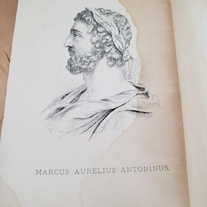 May include: A black and white illustration of Marcus Aurelius Antoninus, a Roman emperor, in profile. He is depicted with curly hair, a beard, and a laurel wreath. The text "MARCUS AURELIUS ANTONINUS" is printed below the illustration.