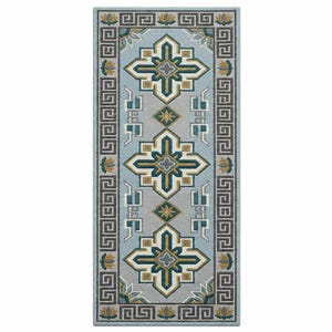 Könnte beinhalten: Ein rechteckiger Teppich mit hellblauem Hintergrund und einem sich wiederholenden geometrischen Muster. Das Design zeigt dunkelgrüne, goldene und weiße kreuzartige Formen und einen Rand mit einem griechischen Schlüsselmuster. Der Teppich ist ein dekoratives Wohnaccessoire.