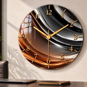 May include: A round wall clock featuring a glossy surface with an abstract wave pattern in shades of black, gray, and copper. The clock face displays gold-colored Arabic numerals and matching gold-colored hour, minute, and second hands.