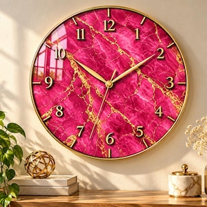 May include: A round wall clock featuring a vibrant magenta marble face with gold veining and a thin gold frame. The clock has gold-colored hour, minute, and second hands, along with raised gold numerals from one to twelve.